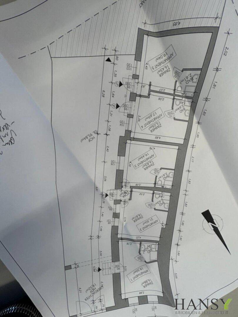 Detaillierter Grundriss eines Stockwerks mit mehreren Apartments und Zimmern.