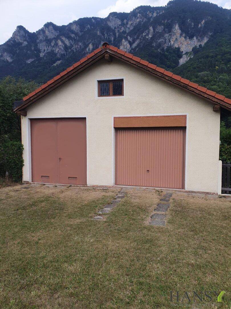 Freistehendes Garagengebäude mit zwei Toren, bietet ausreichend Platz für Fahrzeuge und Lagerung.