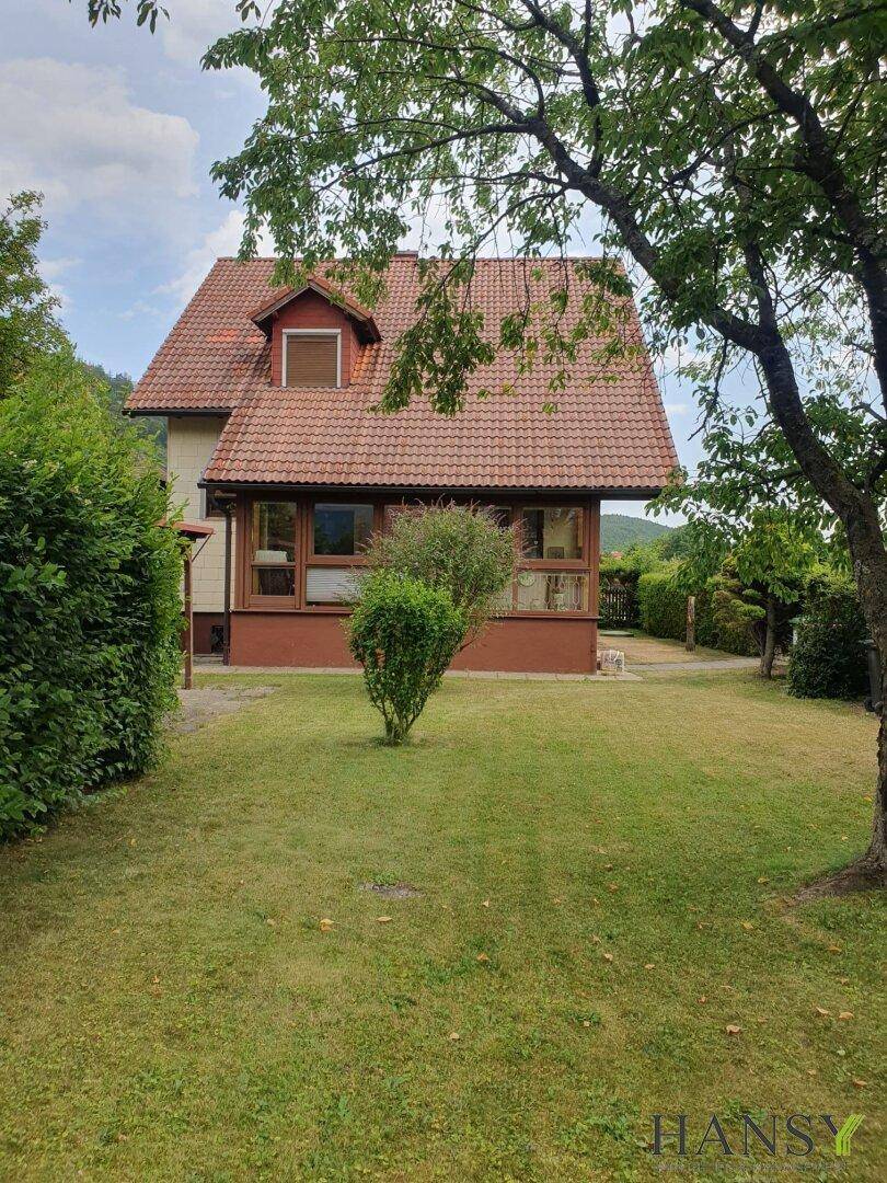 Rückansicht des Hauses mit großem, gepflegtem Garten und altem Baumbestand.