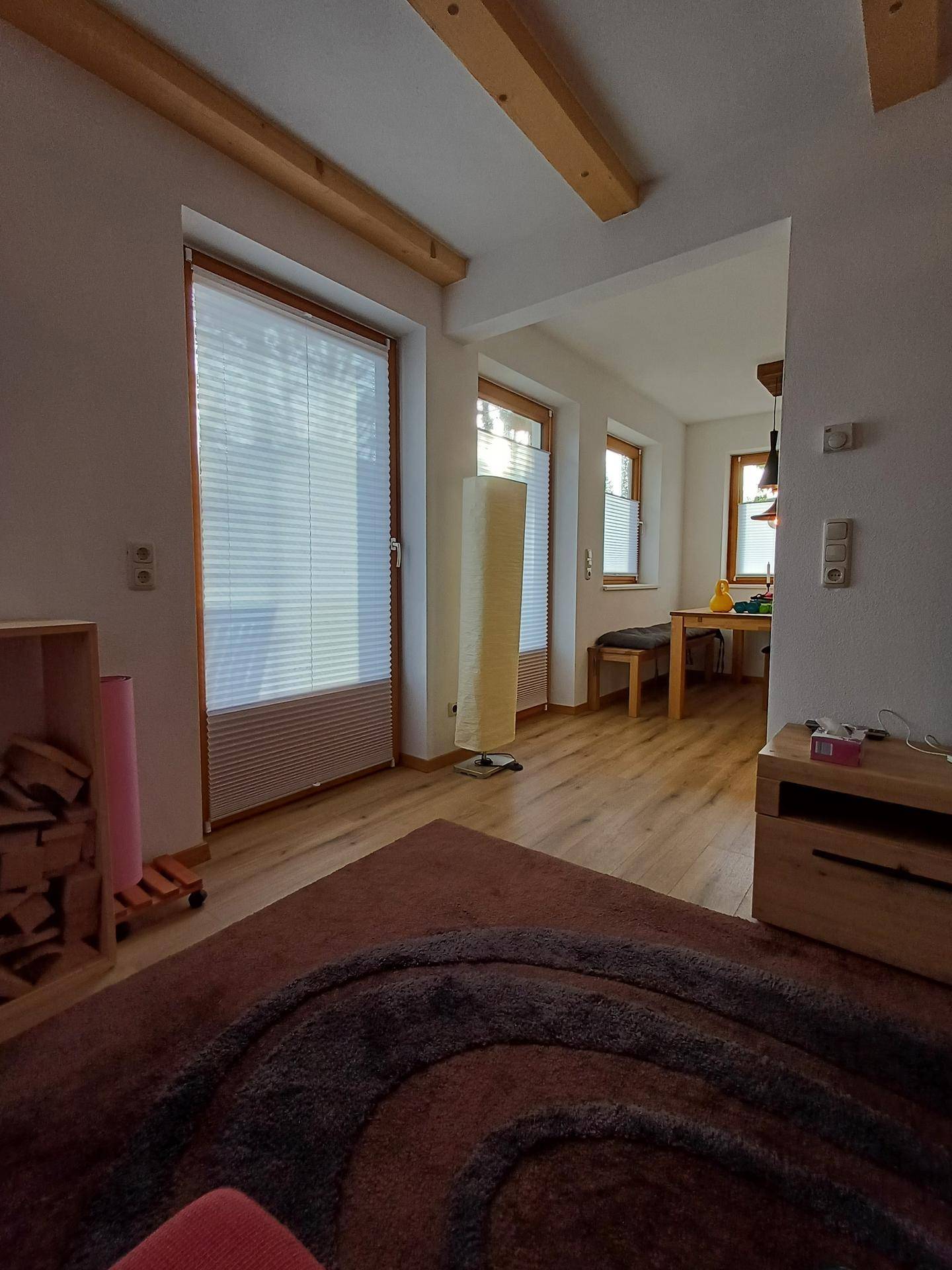 Offener Wohn- und Essbereich mit großen Fenstern, die viel Tageslicht hereinlassen.