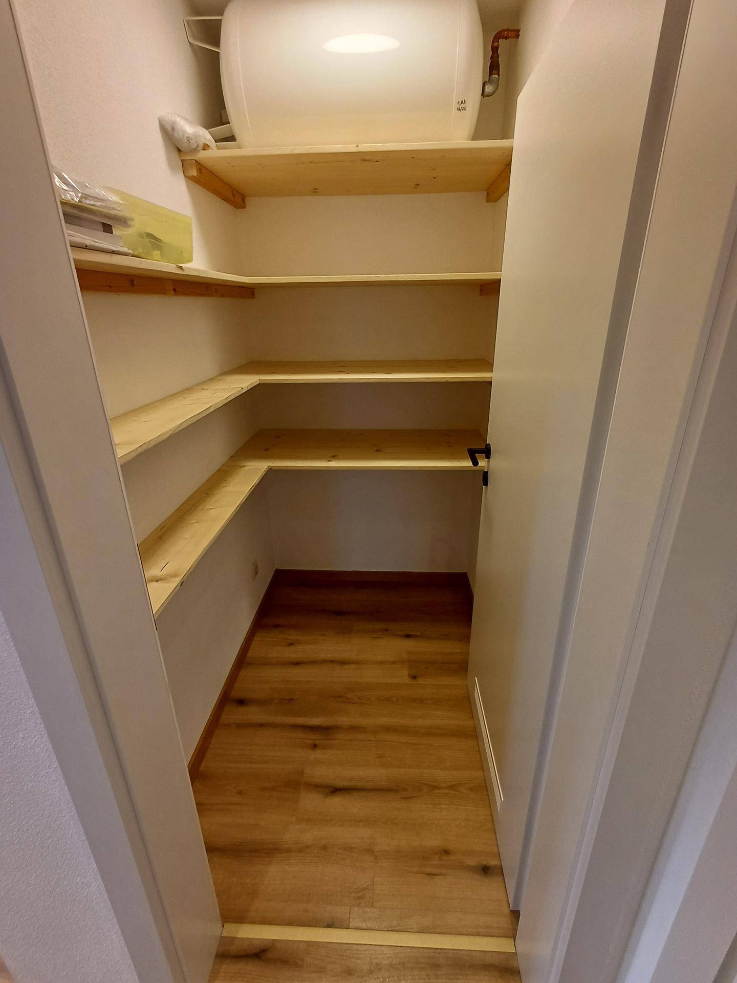Praktische Speisekammer mit Holzregalen für zusätzlichen Stauraum.