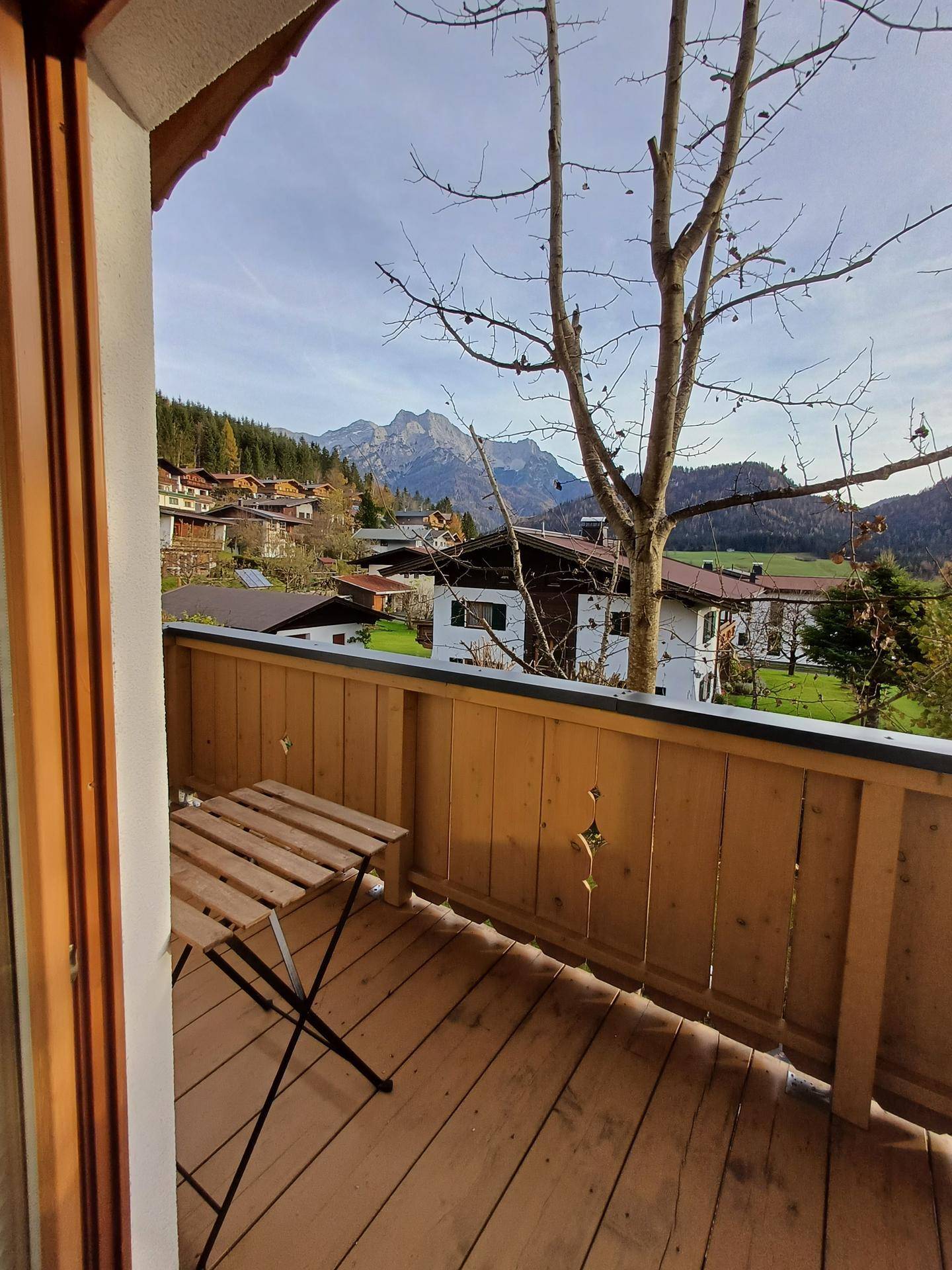 Kleiner Balkon mit Holzboden und Bergblick, ausgestattet mit einem Klapptisch.