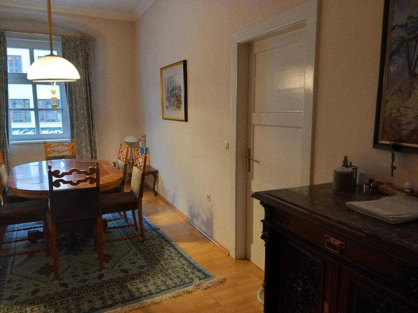Detailansicht des klassischen Essbereichs mit Holzboden und einem antiken Sideboard.