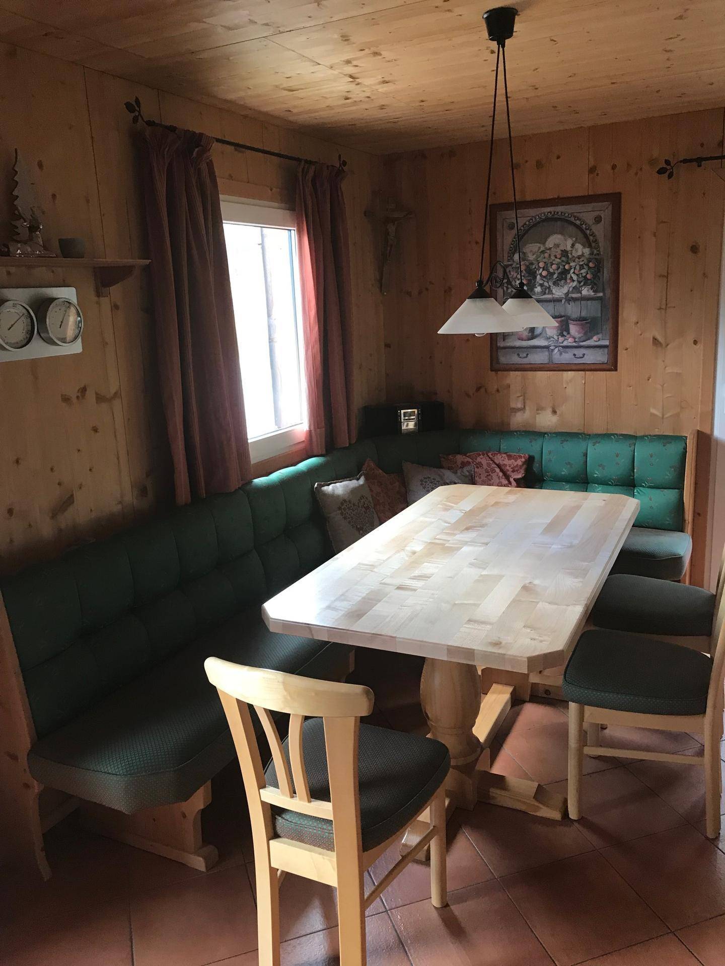 Gemütlicher Essbereich mit Holztisch, Eckbank und gepolsterten Stühlen in traditionellem Stil.