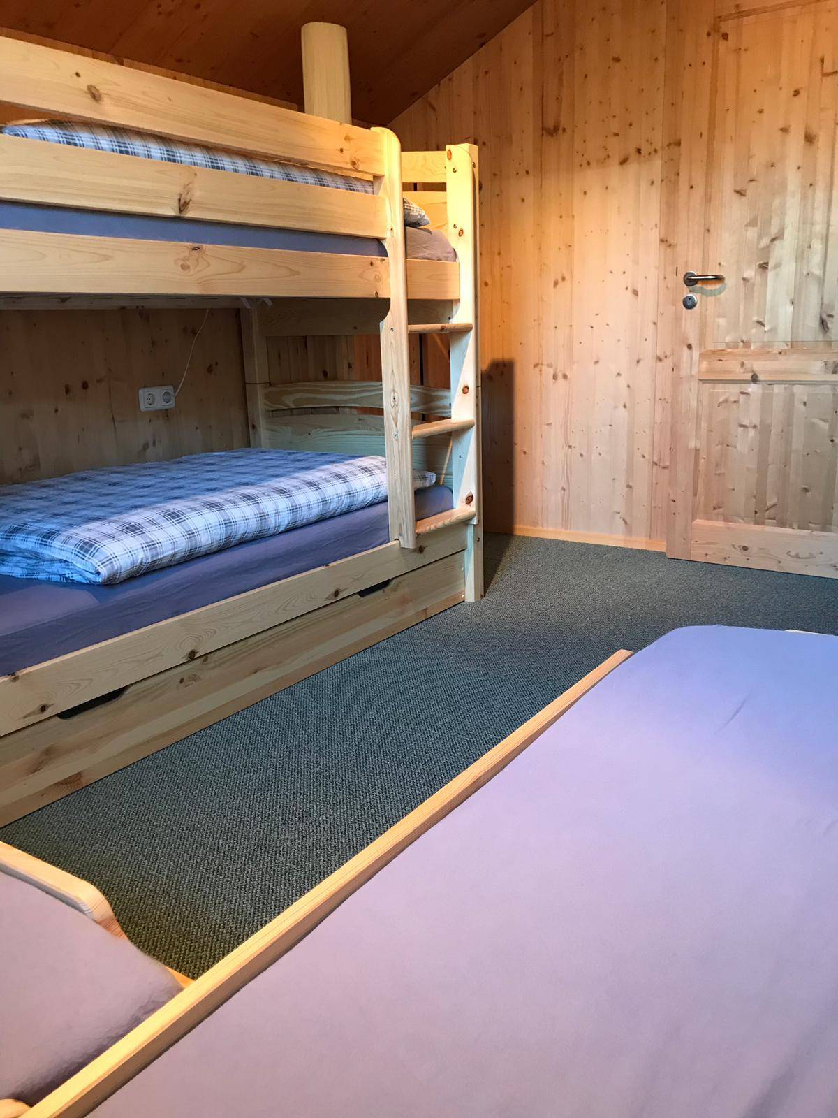 Kinderzimmer mit Etagenbett und Teppichboden, ideal für mehrere Gäste.