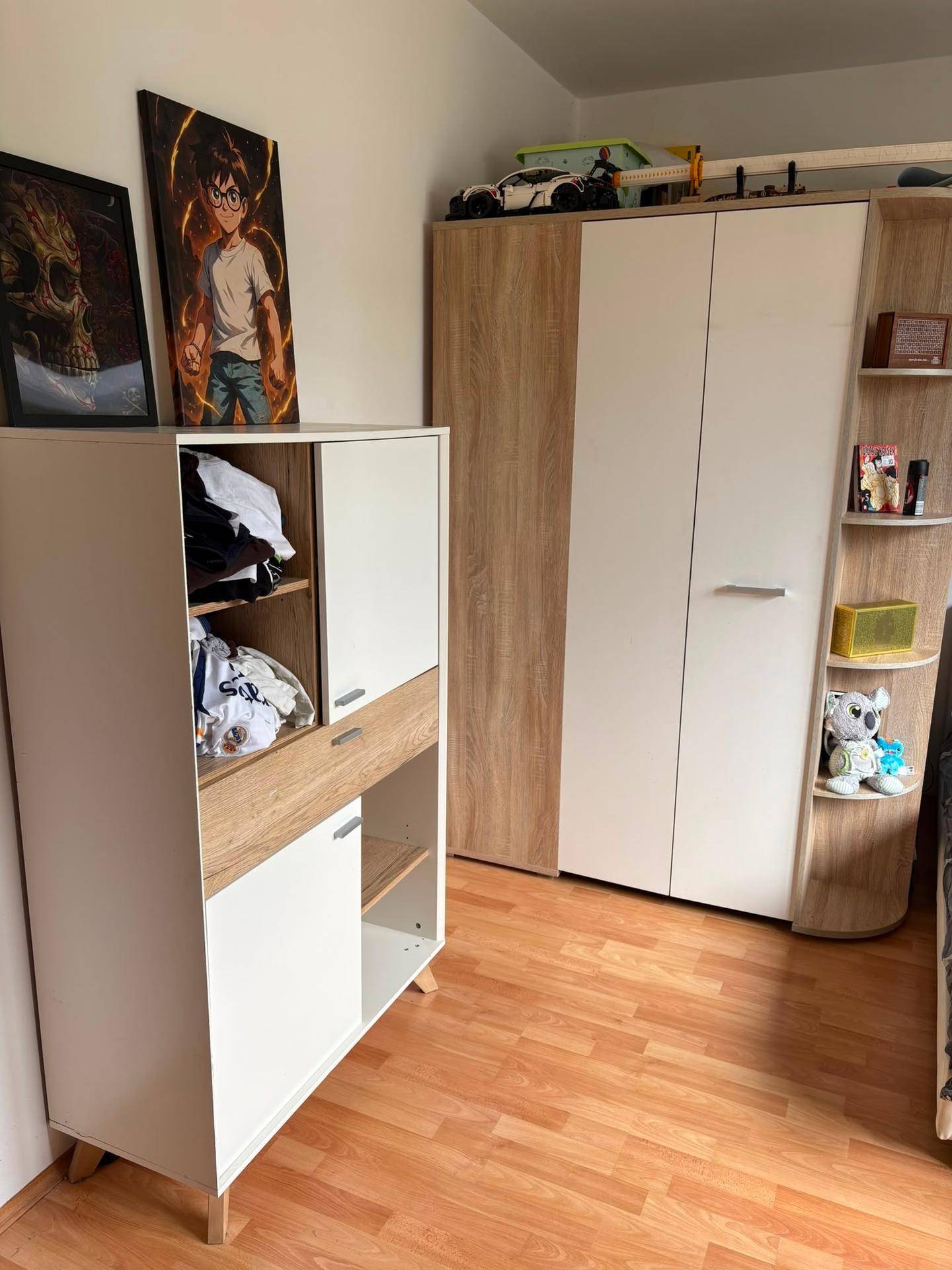 Schlafzimmer mit Laminatboden, hellem Kleiderschrank und einem Regal mit persönlichen Gegenständen.