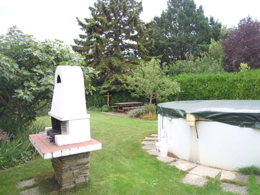 Weitläufiger Garten mit Grillplatz, oberirdischem Pool und einem Picknicktisch unter Bäumen.
