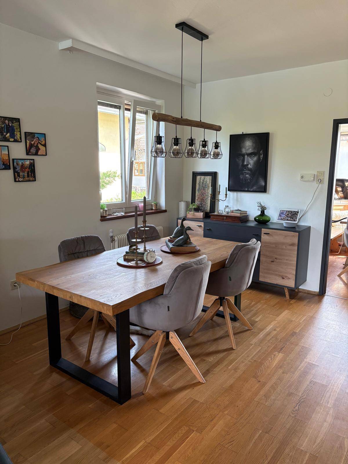 Heller Essbereich mit Holztisch, modernen Stühlen und einem Fenster mit Blick ins Grüne.