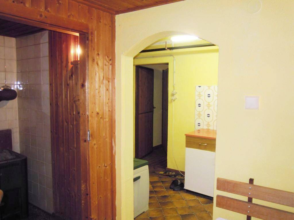 Durchgang zu einem weiteren Raum, mit Holztäfelung und gelben Wänden in der Küche.