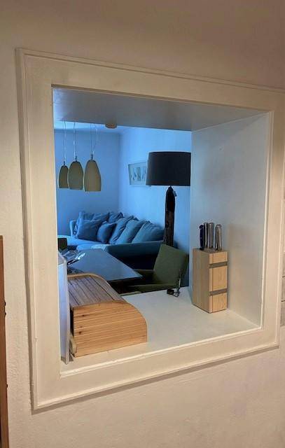 Durchreiche verbindet Küche und Wohnbereich, mit Blick auf Sofa und Esstisch.