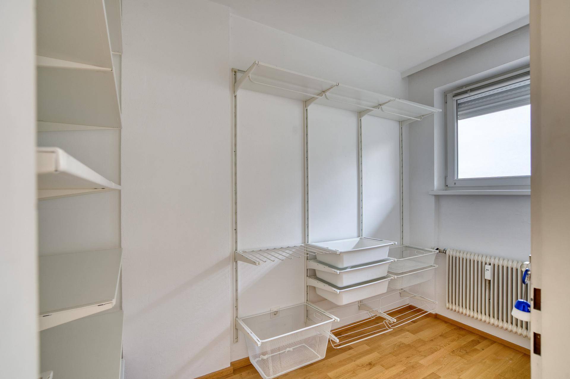 Praktischer Abstellraum mit Regalsystemen und einem Fenster für natürliche Belüftung.