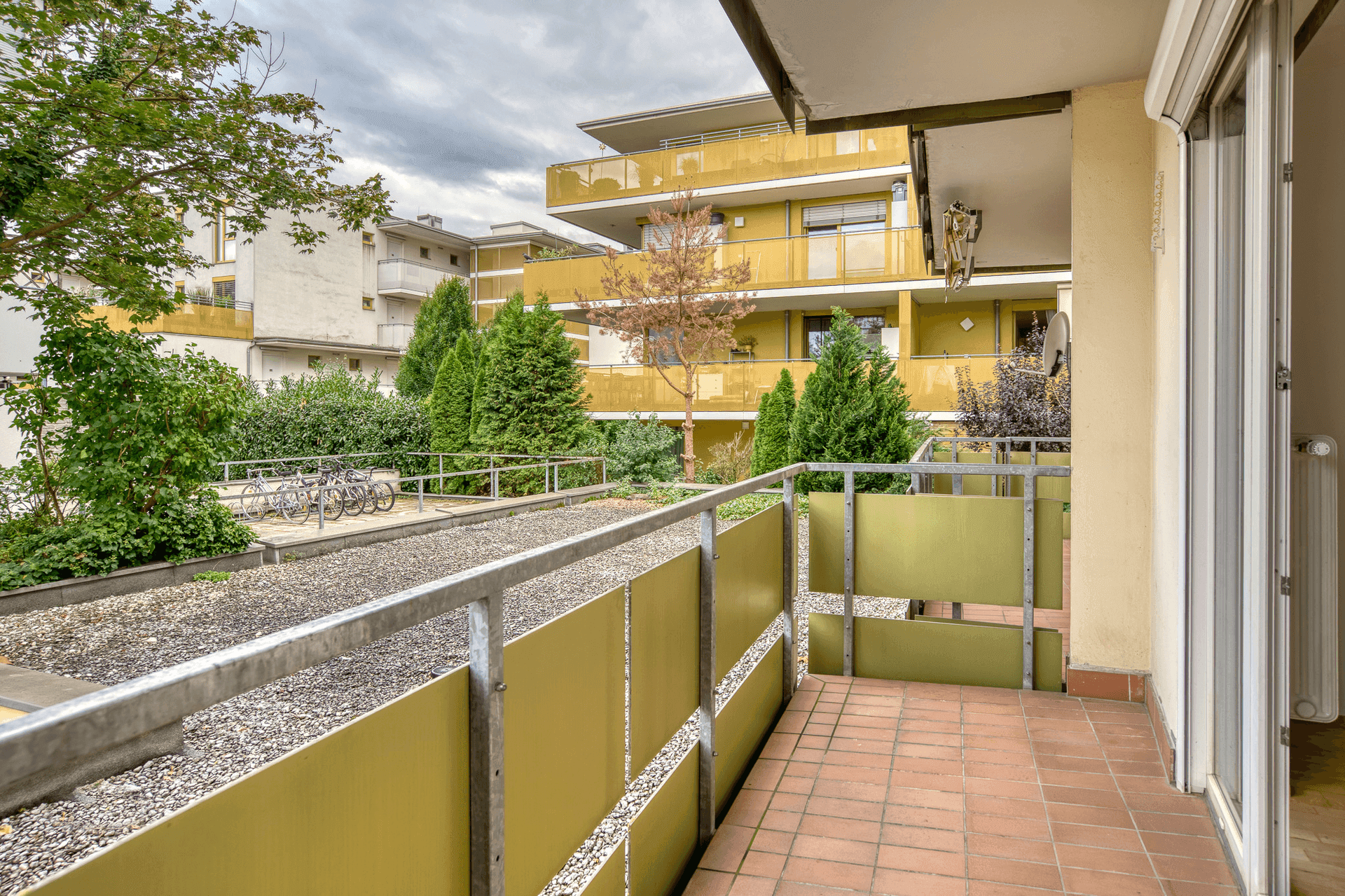 Balkon mit Blick auf die umliegenden Wohngebäude und einen begrünten Innenhof.