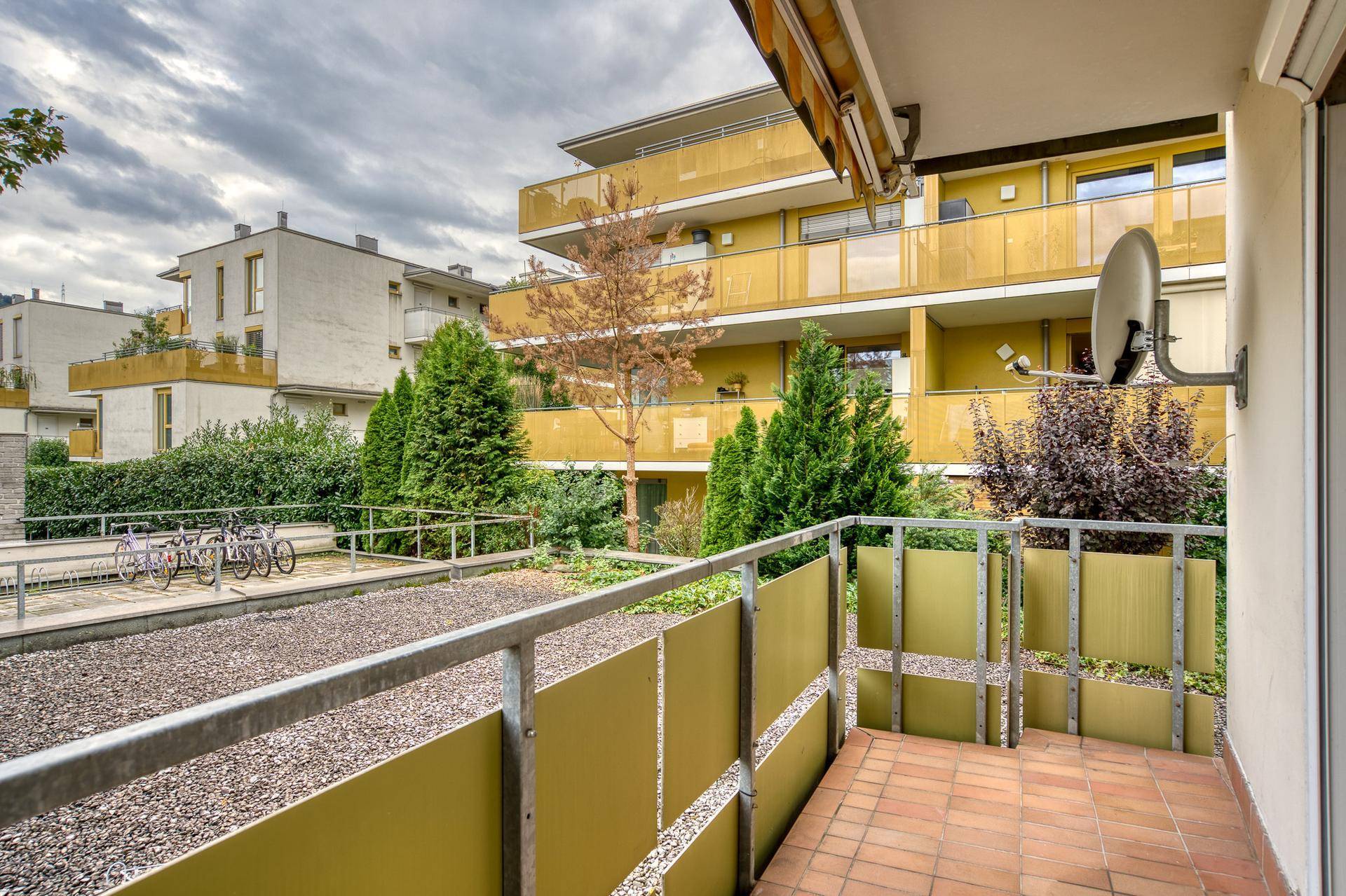 Balkon mit Blick auf die umliegenden Wohngebäude und einen begrünten Innenhof.