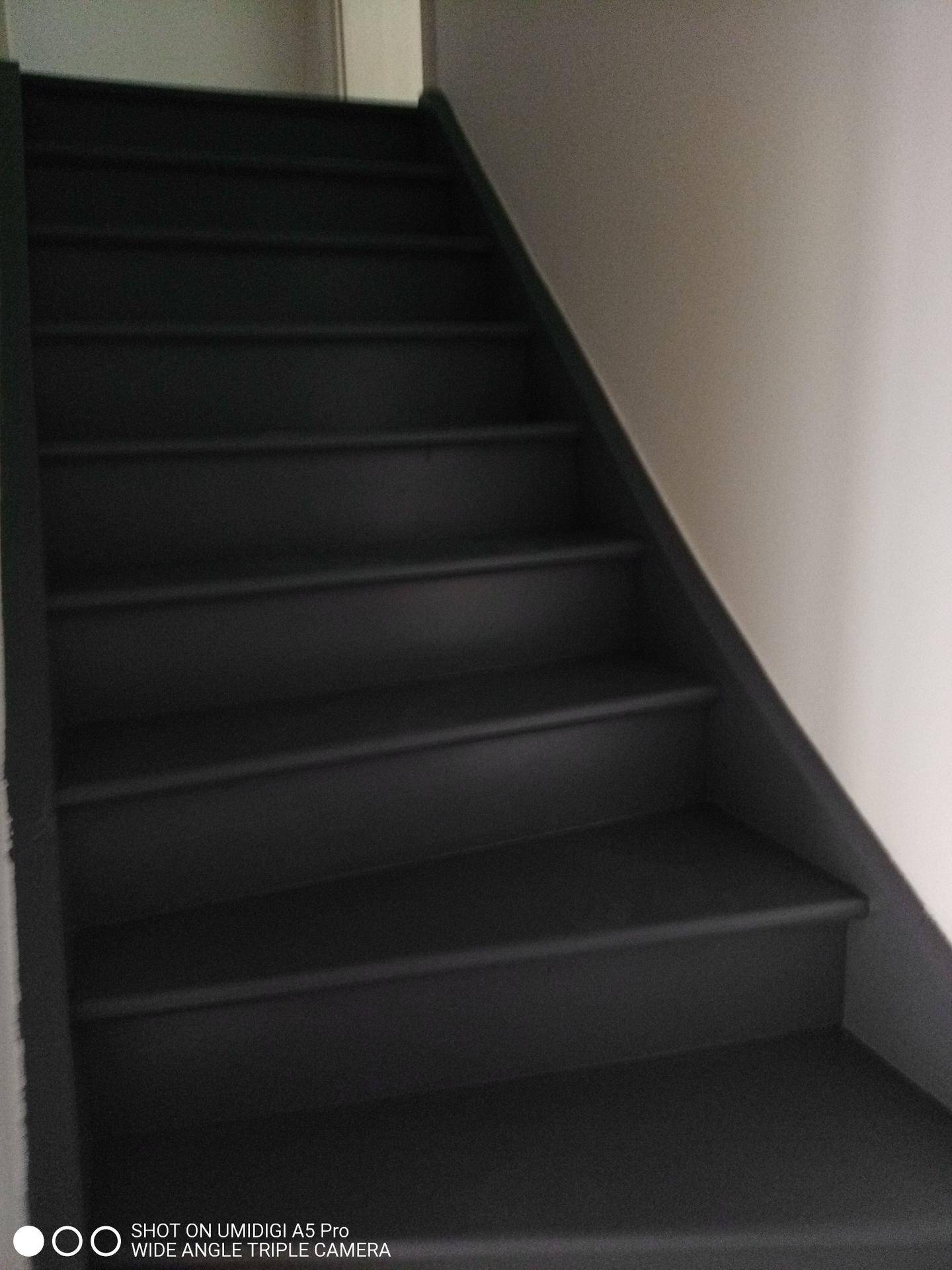 Treppenaufgang mit dunklen Stufen, der die verschiedenen Etagen verbindet.
