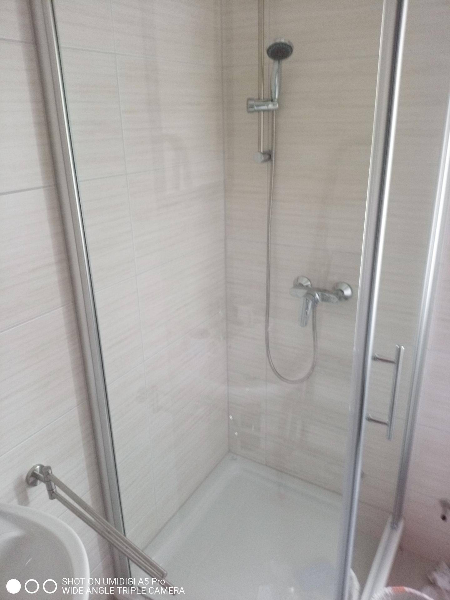 Duschkabine mit Glasabtrennung und modernen Fliesen im Badezimmer.