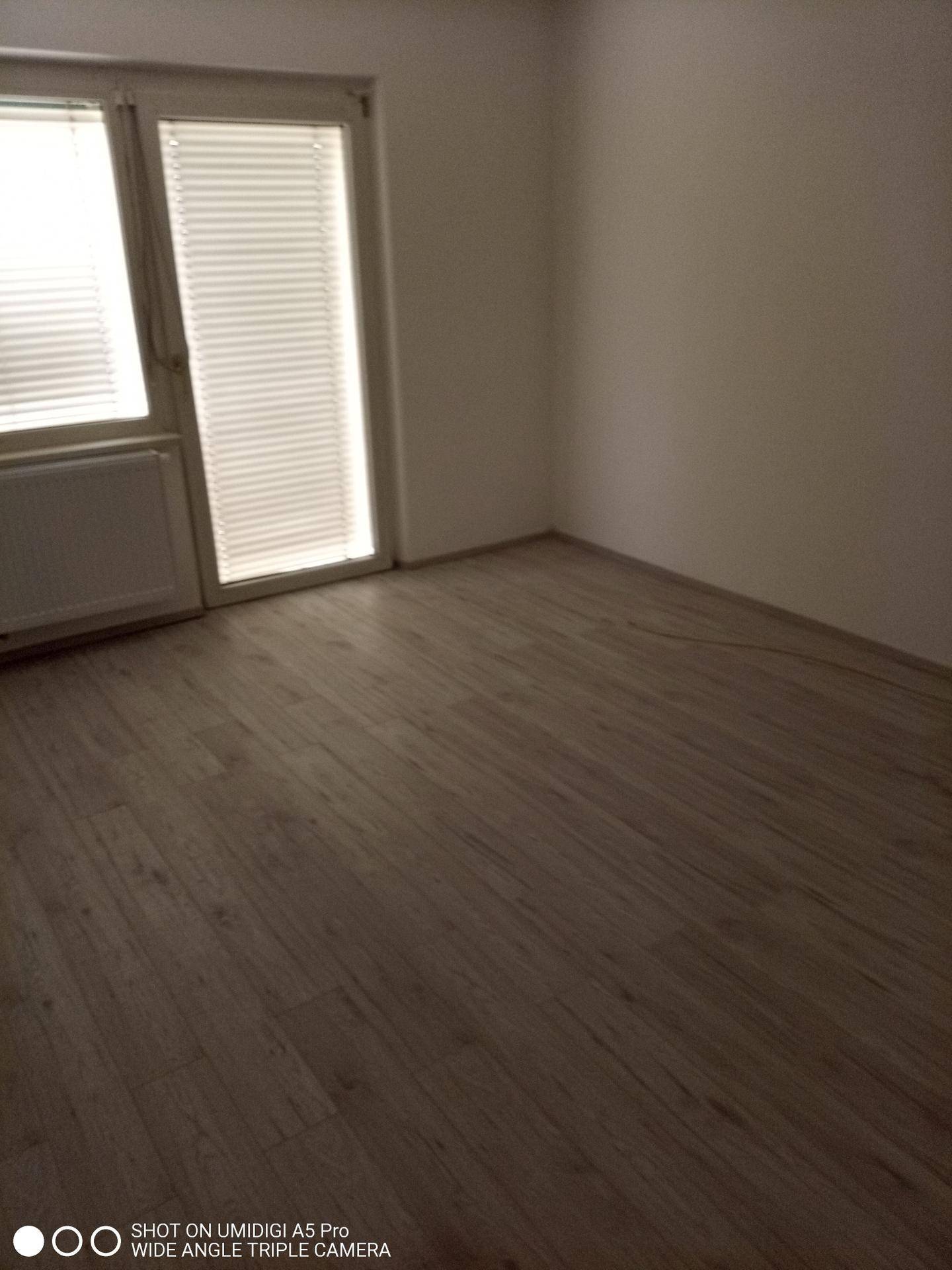 Geräumiges Zimmer mit Laminatboden und Zugang zu einem möglichen Balkon oder Terrasse.