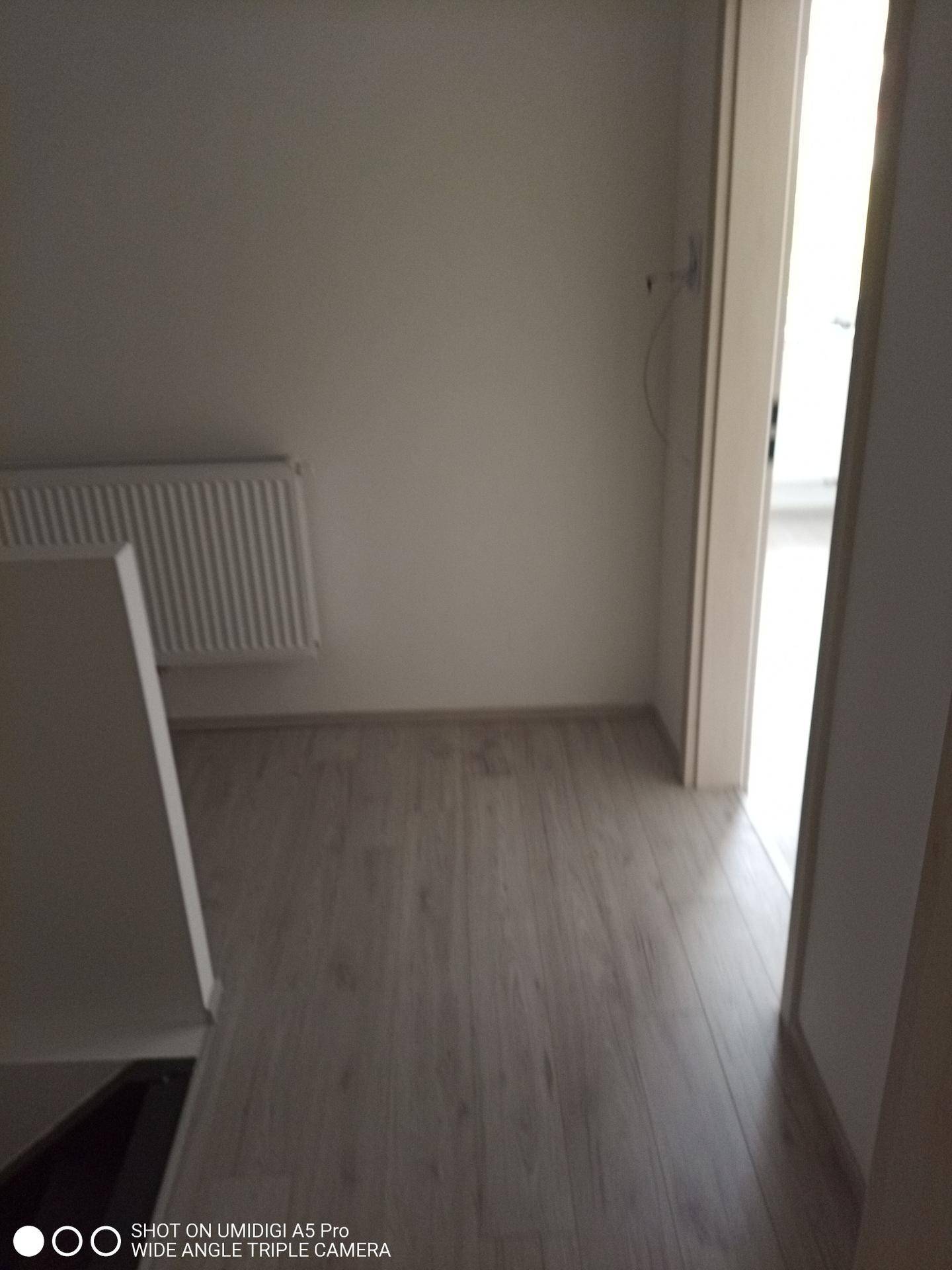 Heller Flur mit hellem Laminatboden und Zugang zu weiteren Räumen.