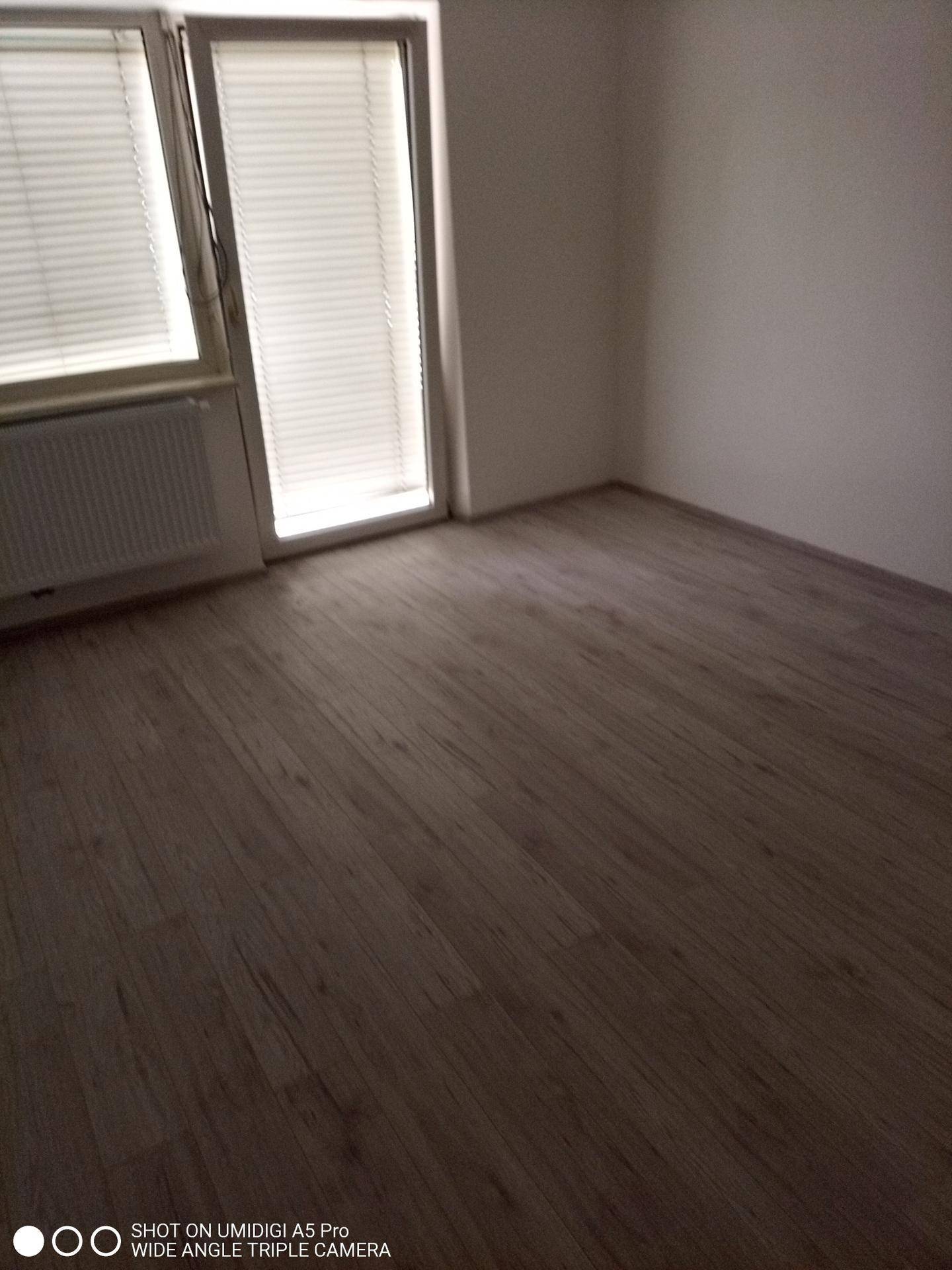 Geräumiges Zimmer mit Laminatboden und Zugang zu einem möglichen Balkon oder Terrasse.
