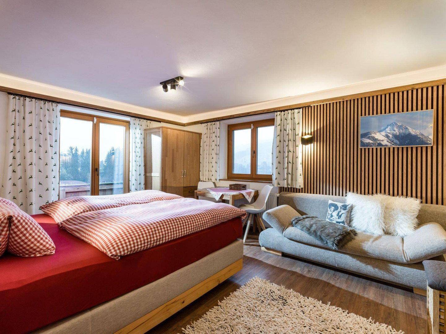 Geräumiges Schlafzimmer mit Doppelbett, Sofa und Zugang zum Balkon.