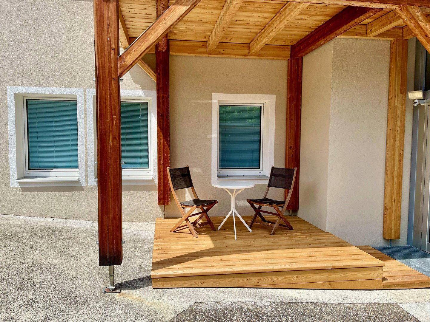 Ebenerdige Holzterrasse mit Sitzgelegenheiten, Teil der neuen Balkonkonstruktion.