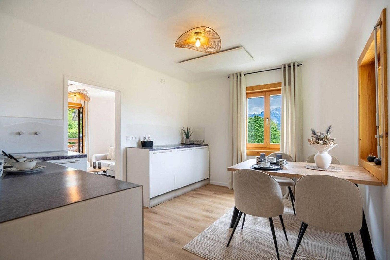 Heller Essbereich mit Holztisch, modernen Stühlen und Fensterblick ins Grüne.
