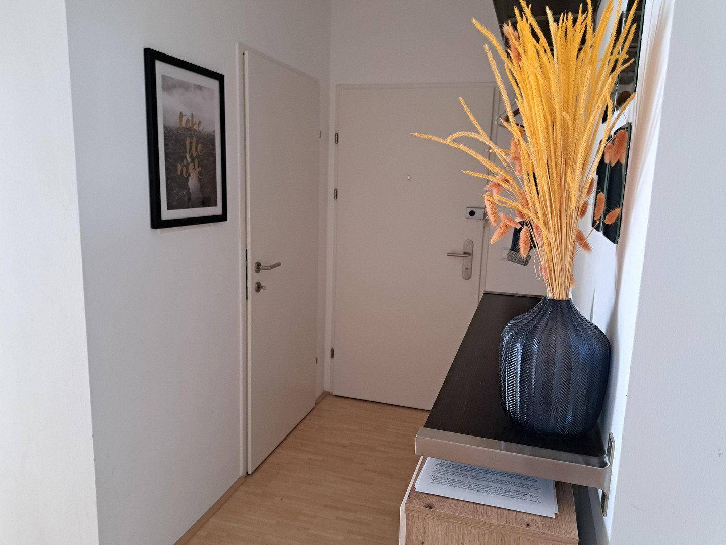 Heller Eingangsbereich mit Holzboden und moderner Dekoration.