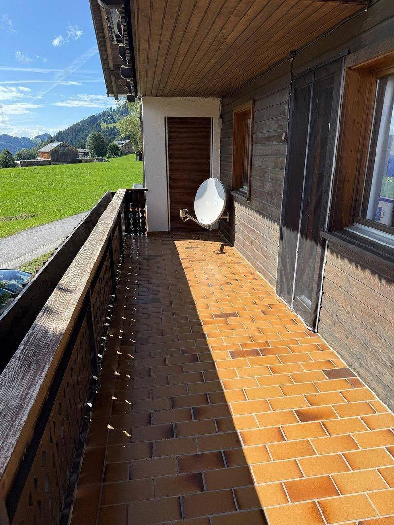 Geräumiger Balkon mit Holzboden und Fliesen, bietet einen weiten Blick auf die Landschaft.