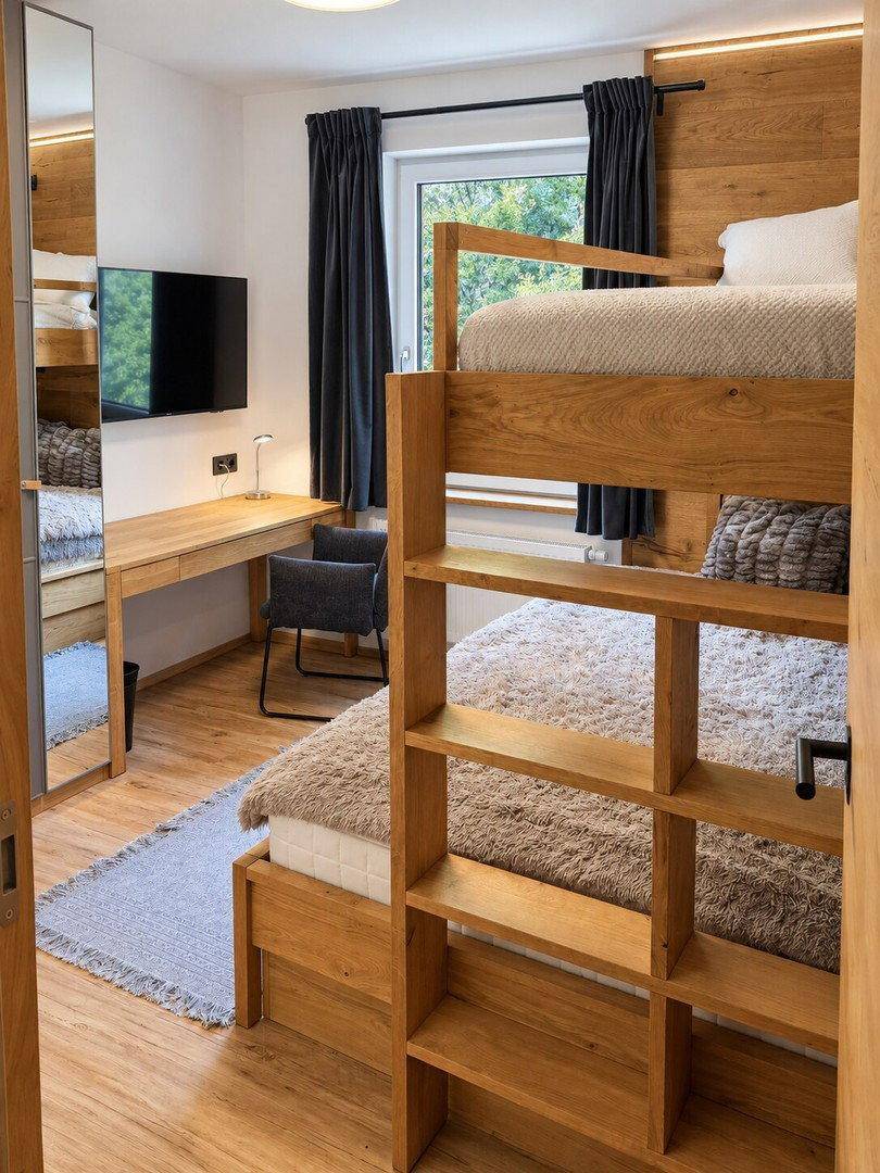 Kinderzimmer mit Etagenbett aus Holz, Schreibtisch und Fernseher, ideal für Familien.
