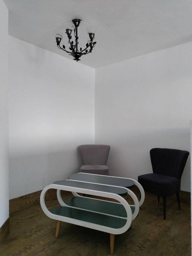 Gemütliche Sitzecke mit modernen Couchtischen und zwei Sesseln in einem hellen Raum.