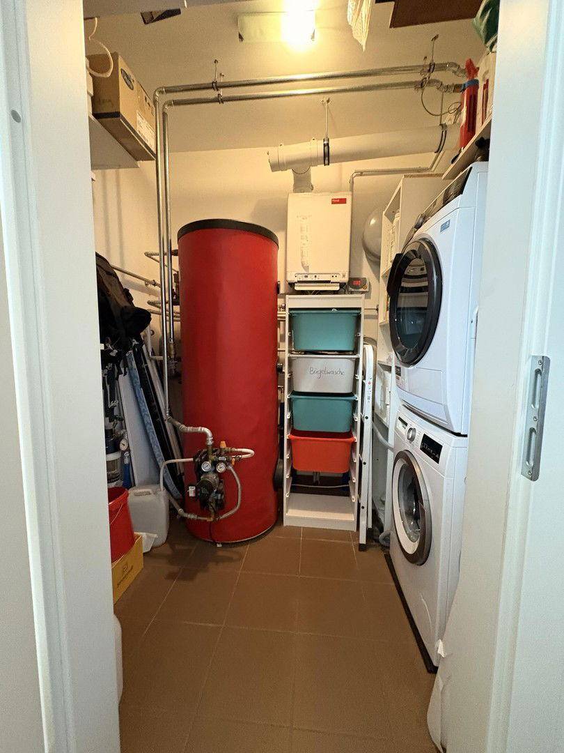 Praktischer Hauswirtschaftsraum mit Waschmaschine, Trockner und Warmwasserspeicher.