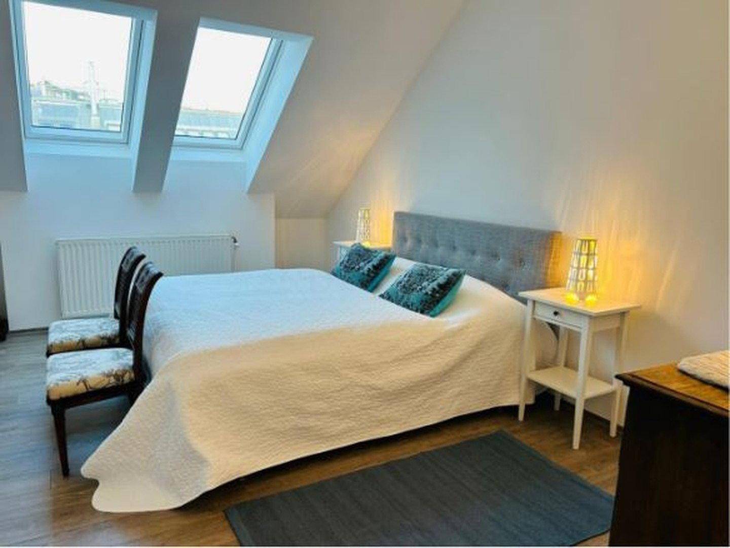 Gemütliches Schlafzimmer im Dachgeschoss mit Doppelbett, Nachttischen und zwei Dachfenstern.