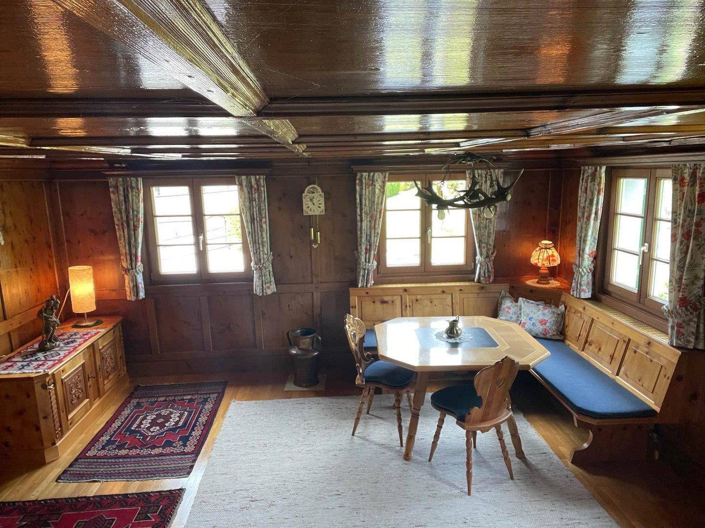 Gemütlicher Essbereich im alpinen Stil mit Holztäfelung, Kassettendecke und traditionellen Möbeln.