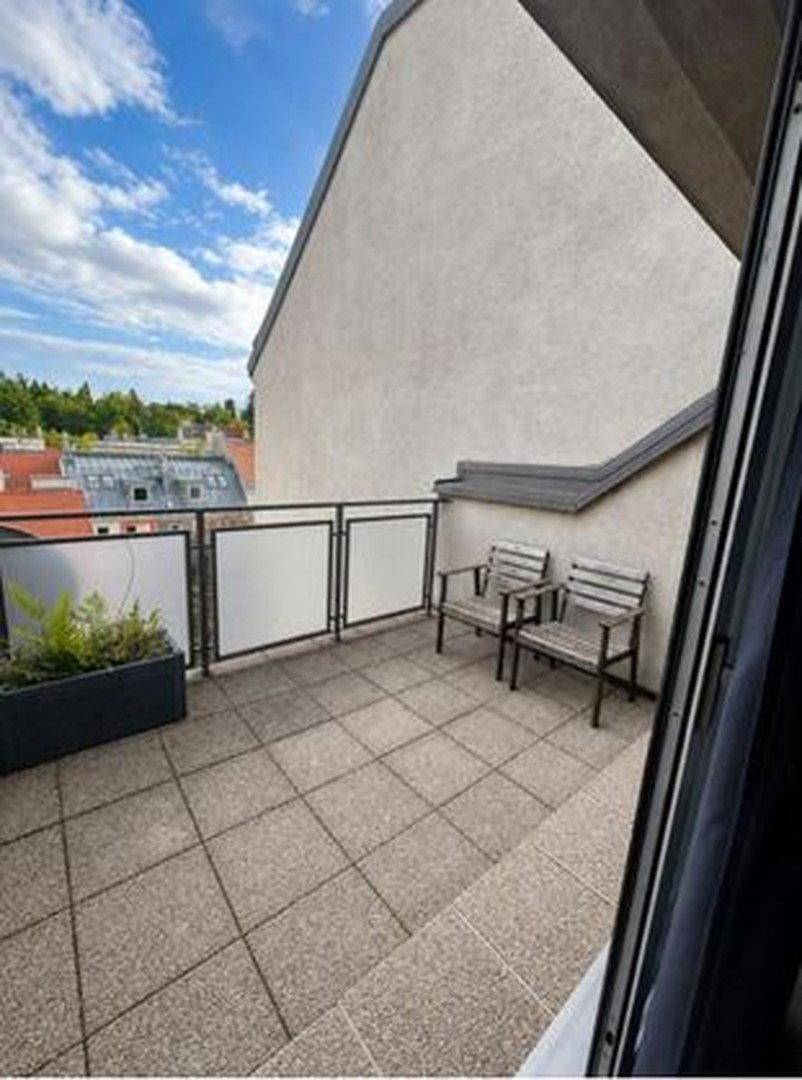 Geräumige Dachterrasse mit Fliesenboden, Sitzgelegenheiten und Blick auf die Umgebung.