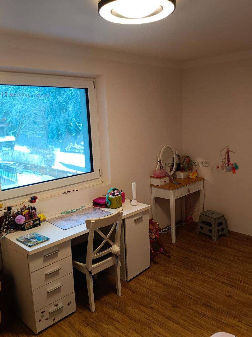Helles Kinderzimmer mit Schreibtisch, Schminktisch und Blick ins Grüne.