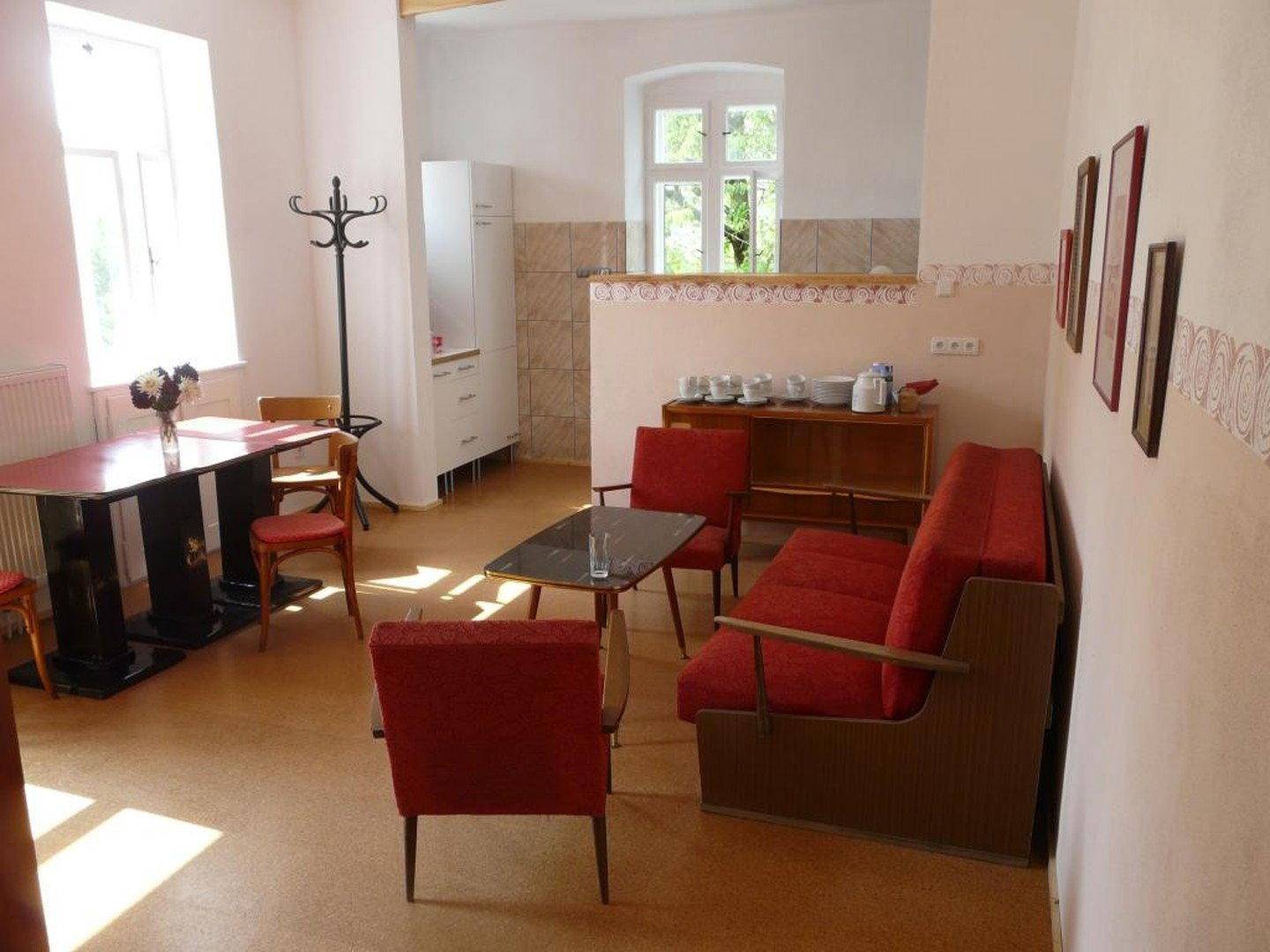Gemütlicher Wohn- und Essbereich mit Vintage-Möbeln und kleiner Küchenzeile.