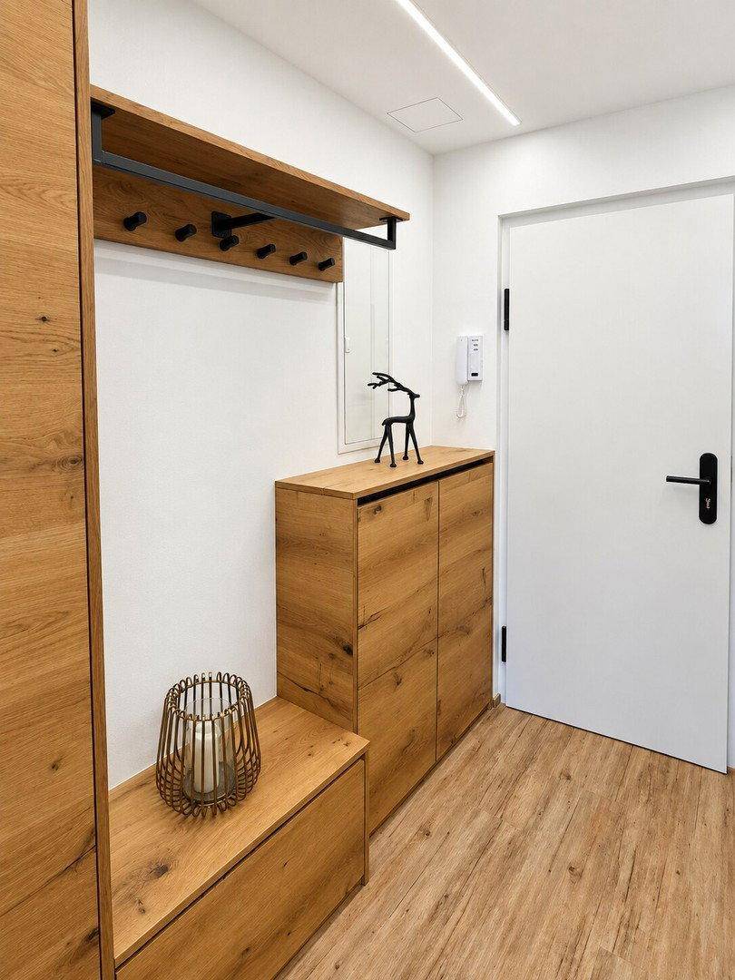 Eingangsbereich mit Garderobe, Schuhschrank aus Holz und Spiegel, praktisch und einladend gestaltet.