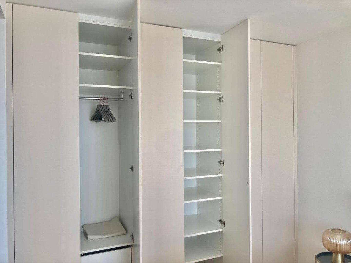 Offener Einbauschrank mit viel Stauraum, Kleiderstange und Regalfächern.
