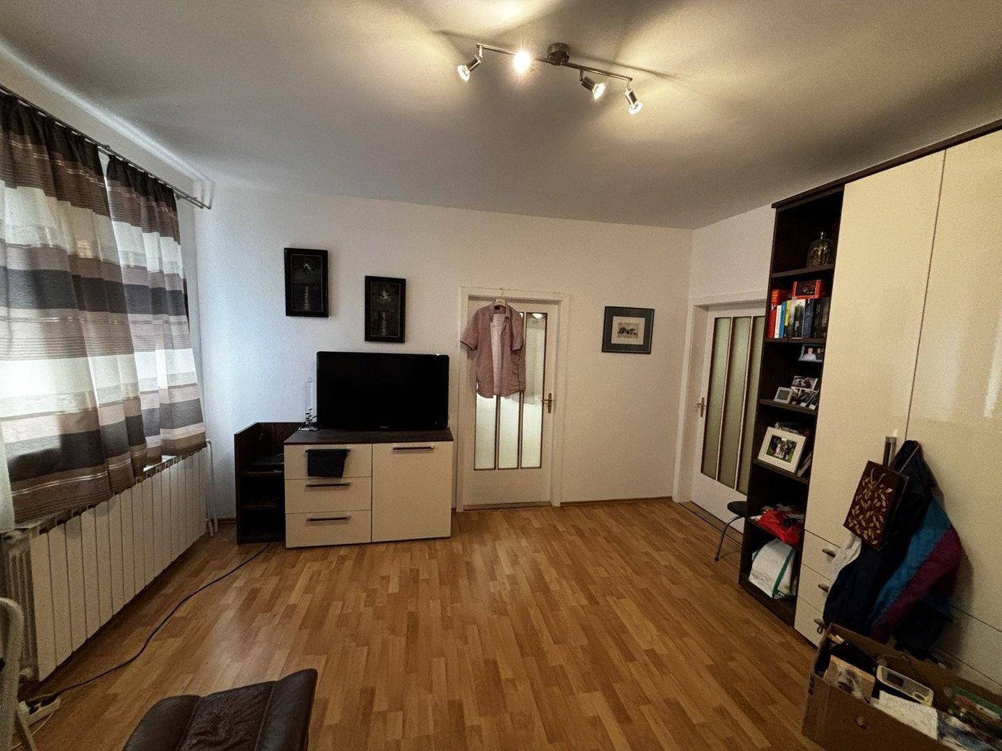 Wohnraum mit Laminatboden, TV-Möbel und modernen Schränken.