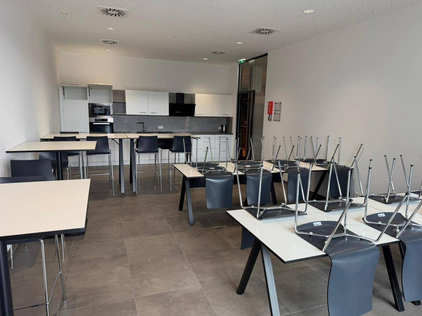 Großer Essbereich mit vielen Tischen und Stühlen, ideal für Mitarbeiterpausen und Veranstaltungen.