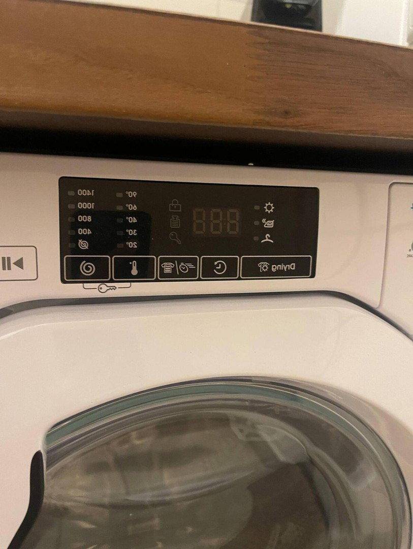 Nahaufnahme des Bedienfelds einer modernen Waschmaschine mit digitaler Anzeige und Programmauswahl.