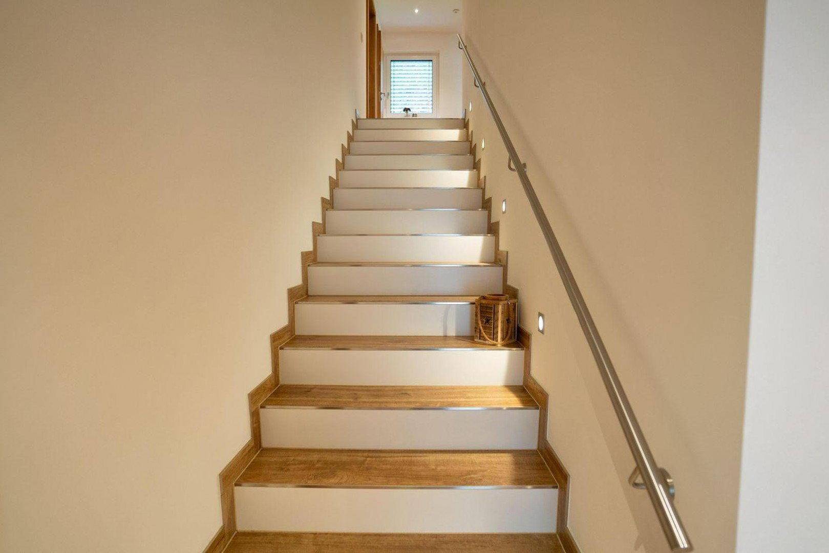 Helle Holztreppe mit Metallgeländer, die die verschiedenen Etagen des Hauses verbindet.