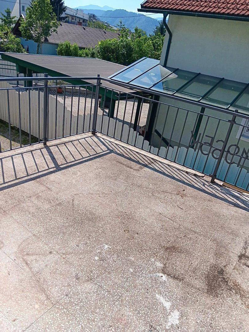 Geräumige Betonterrasse mit Metallgeländer und Blick auf die umliegende Landschaft.