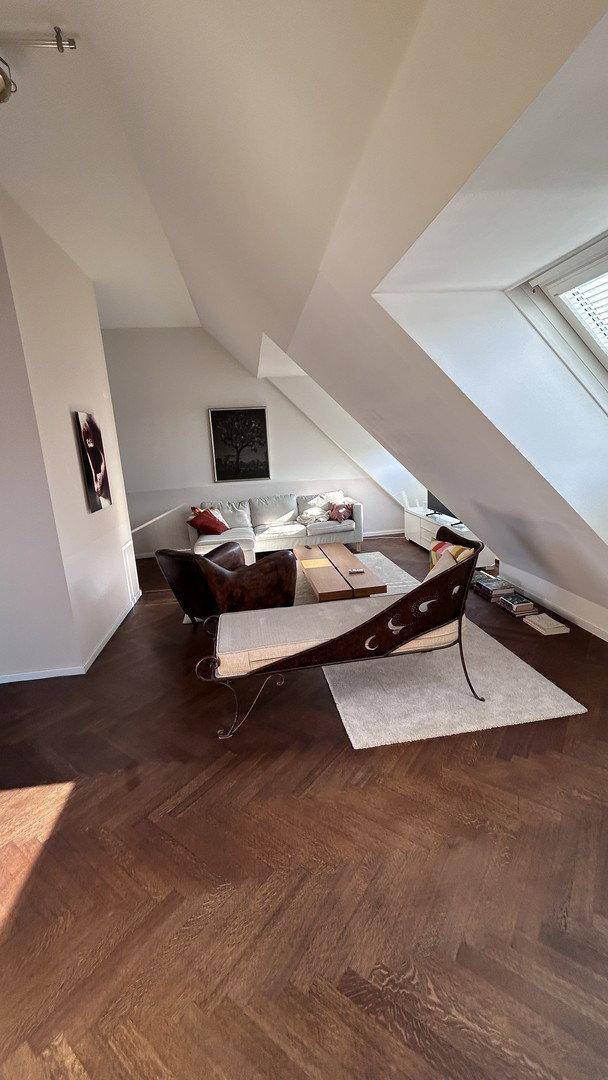 Geräumiges Wohnzimmer mit Holzboden, bequemen Sofas und viel Tageslicht.