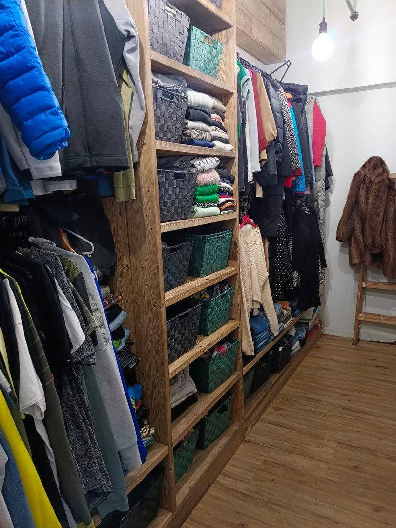 Geräumiger begehbarer Kleiderschrank mit offenen Regalen und viel Stauraum für Kleidung.