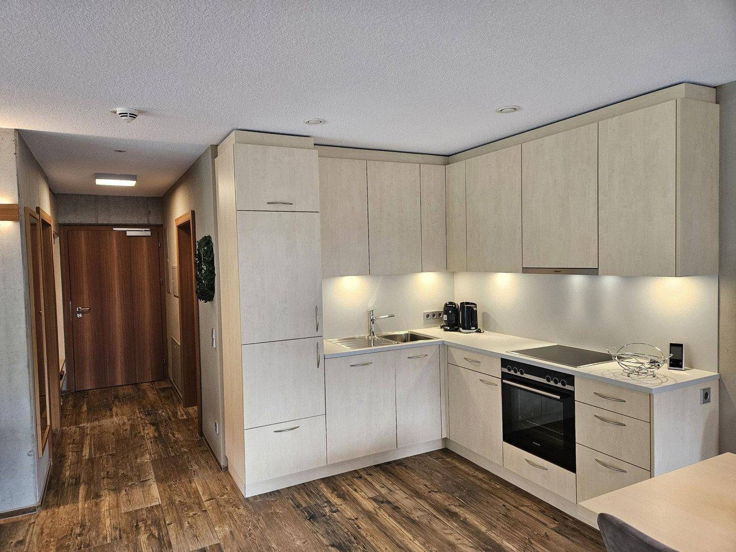 Moderne Einbauküche in hellem Design mit Kochfeld, Backofen und viel Stauraum.