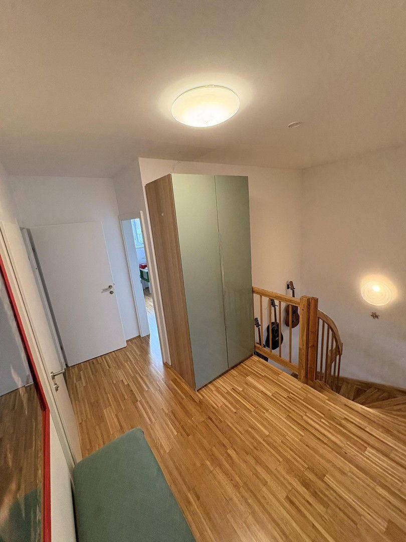 Oberer Treppenabsatz mit Parkettboden und einem großen Schrank für zusätzlichen Stauraum.