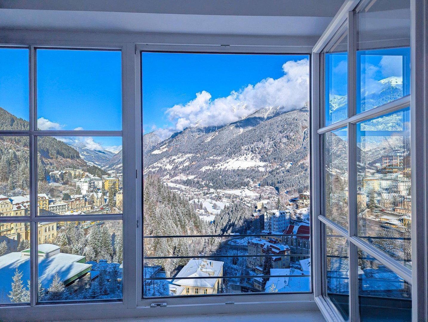 Große Fenster bieten einen spektakulären Blick auf die verschneite Bergwelt und das Tal.