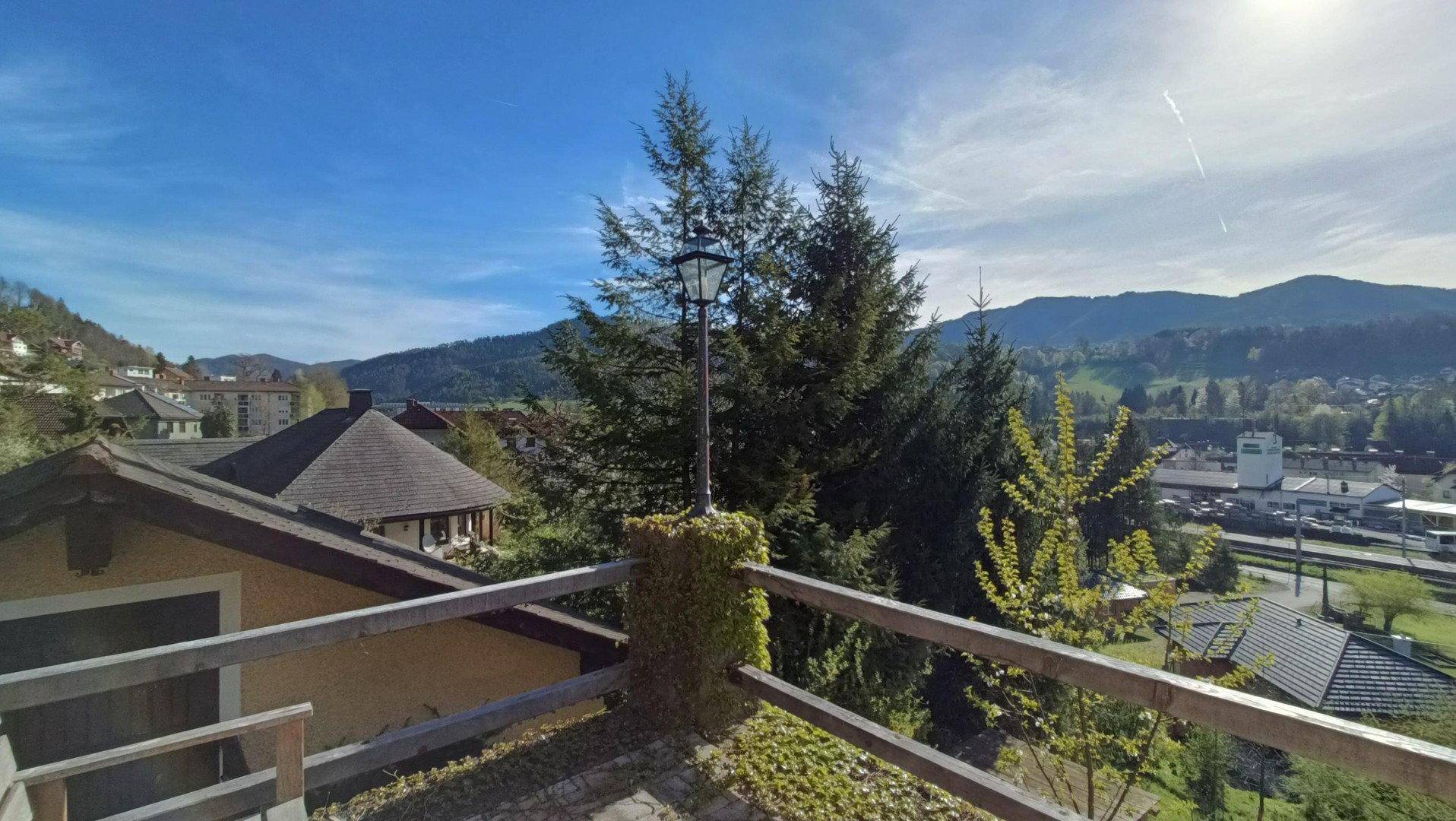Panoramablick vom Balkon über eine malerische Stadt und die umliegenden Berge.