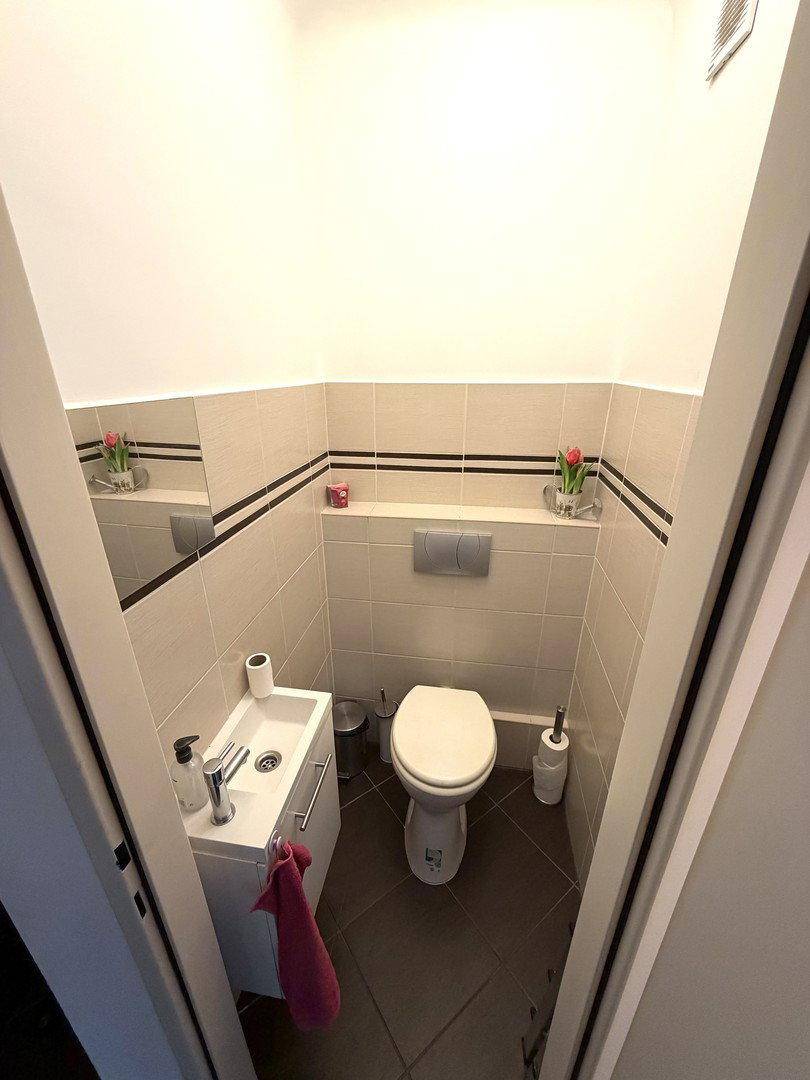 Kleines Gäste-WC mit Waschbecken und Toilette, sauber und funktional gestaltet.
