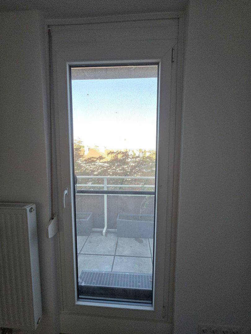 Glastür bietet Zugang zur Terrasse und lässt viel Tageslicht in den Raum.